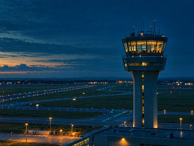 Tour de contrôle d'aéroport éclairée à la tombée de la nuit